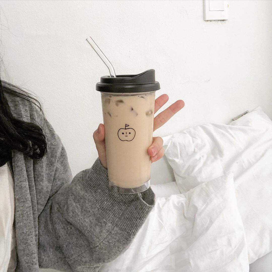cream aesthetic person holding milk tea